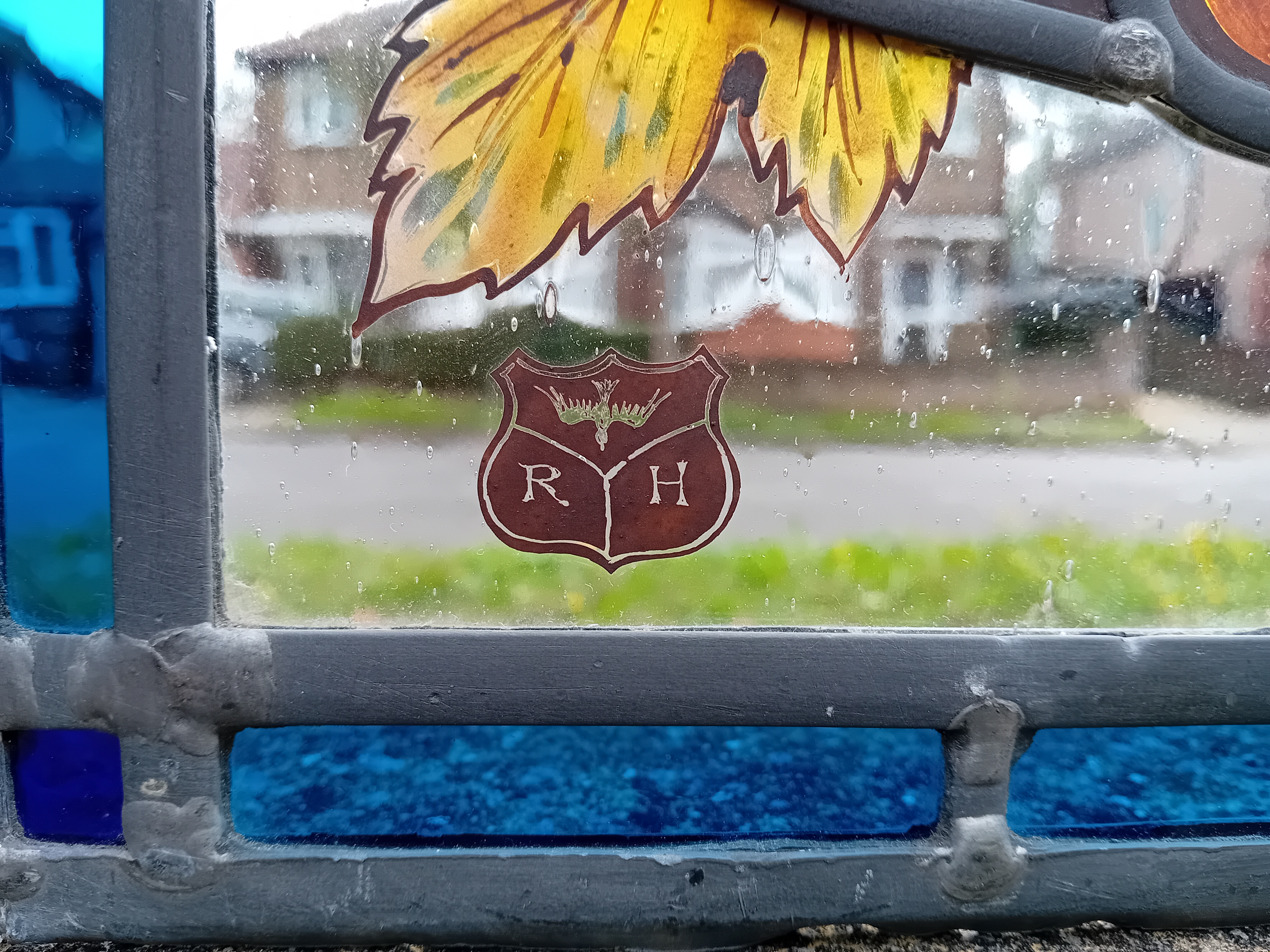 the maker mark RH which stands for Robert Roy Hickling within a leaded stained glass window panel